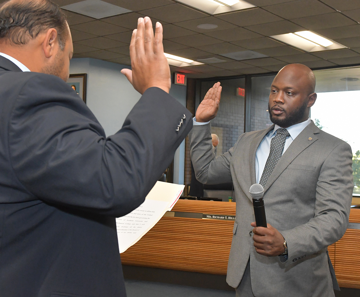Brandon Decuir, Board counsel, administers the oath to Garvey.